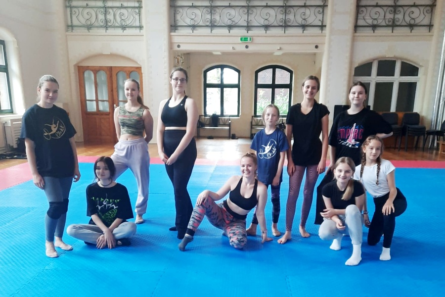 grupa dziewcząt na macie gimnastycznej pozuje do zdjęcia