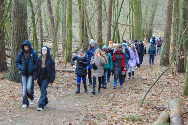 grupa turystów na leśnym szlaku