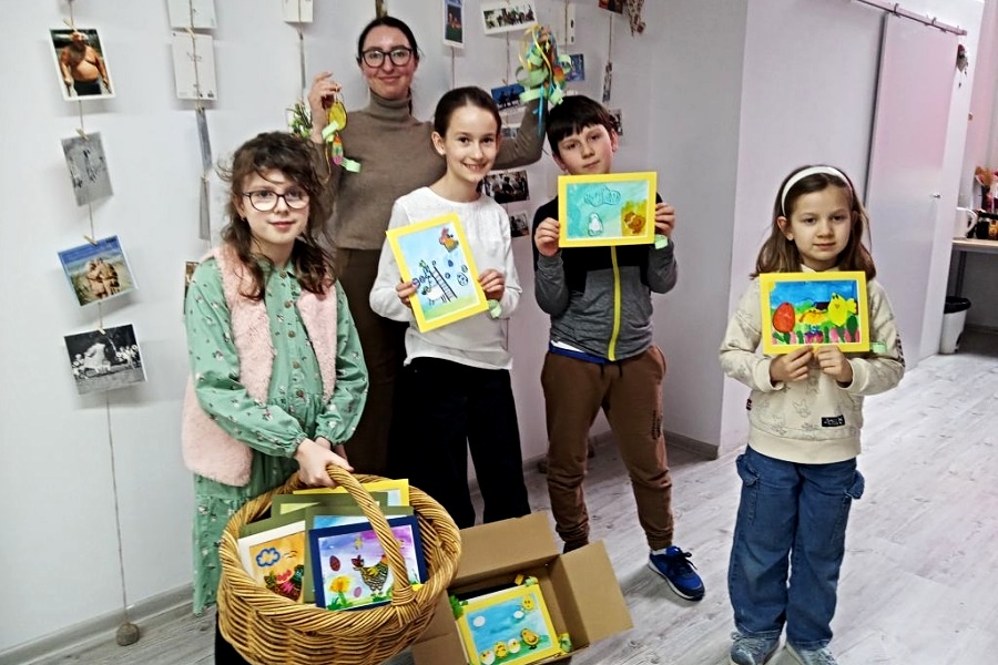 grupa dzieci ze swiatecznymi kartkami pozuje do zdjęcia