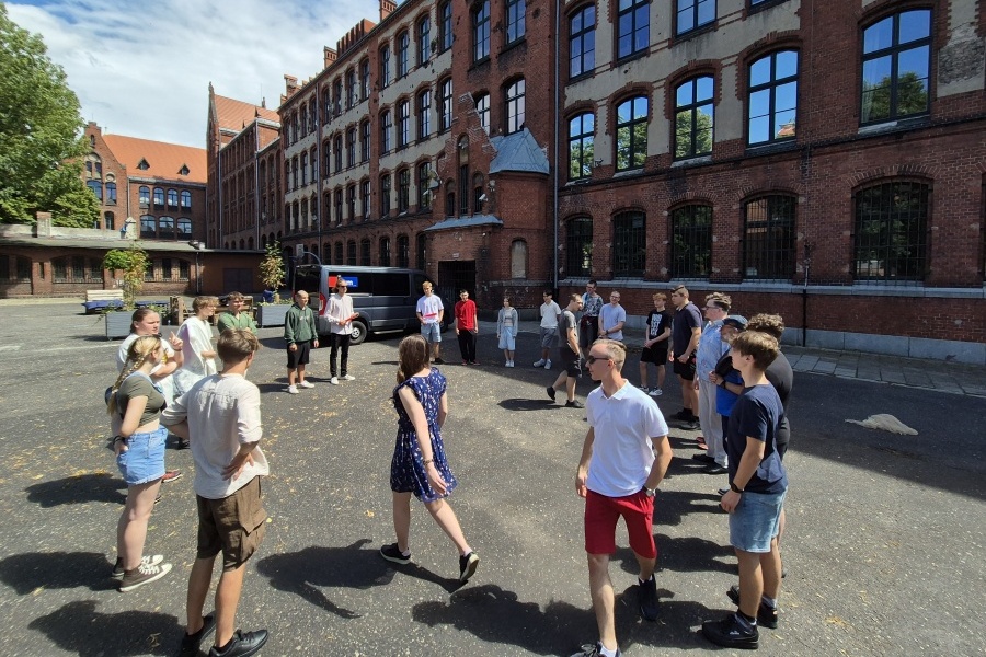 grupa młodzieży stoi w kole na boisku