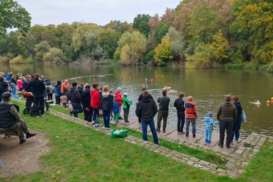 grupa uczestników pokazu stoi przy Jeziorze Rusałka