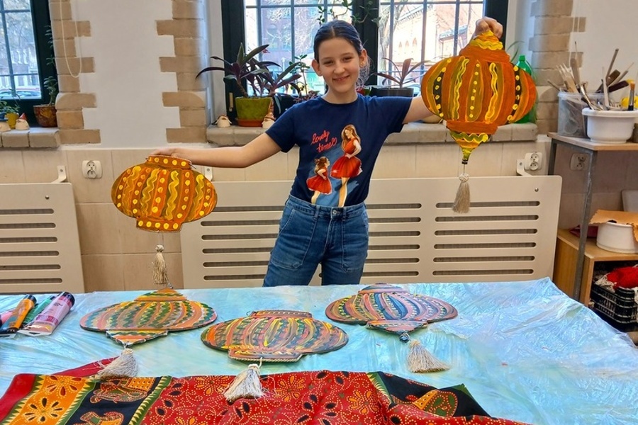 dziewczynka stoi i trzyma dwa lampiony