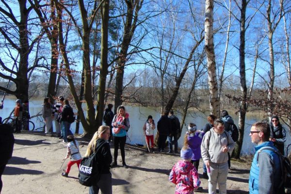 grupa turystów na szlaku w tle jezioro