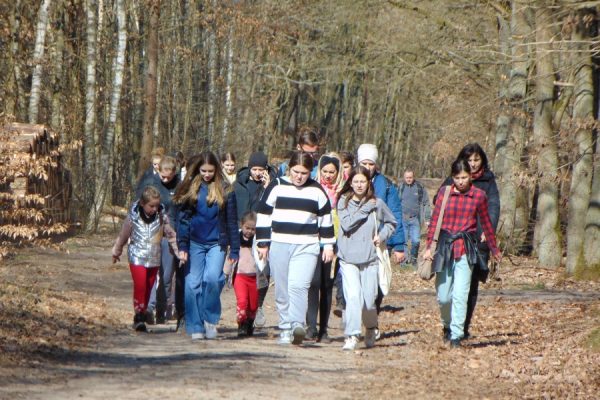 grupa turystów na leśnym szlaku