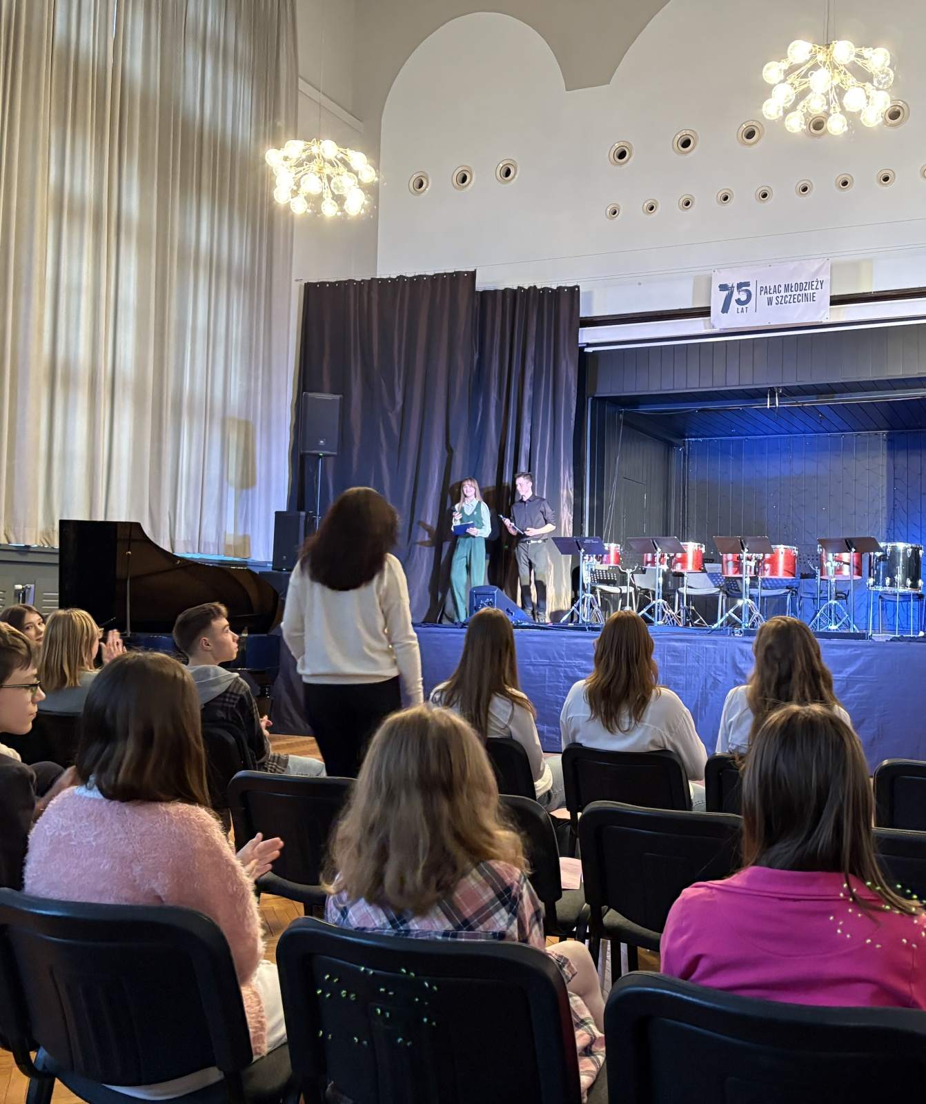 na pierwszym planie publiczność dalej scena