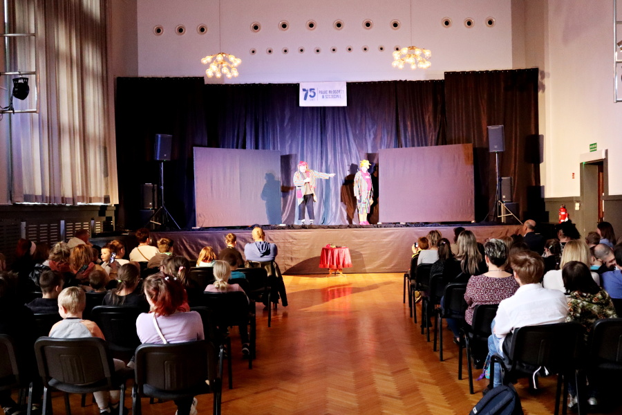 dwoch aktorów na scenie na pierwszym planie publiczność