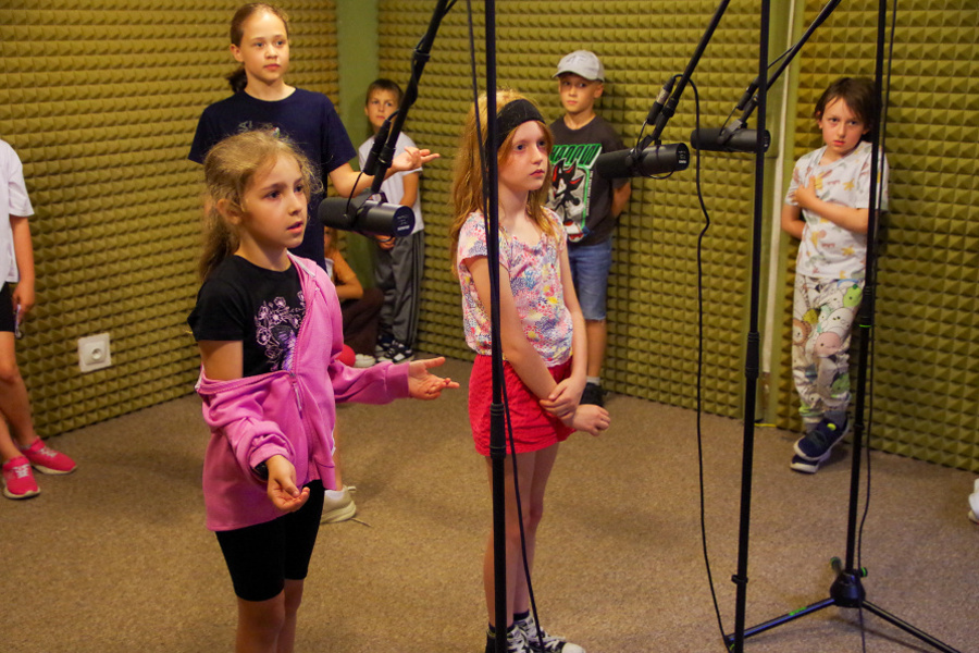 grupa dzieci z mikrofonami w studiu