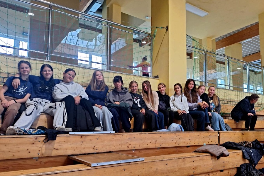 grupa dziewcząt siedzi na ławkach w trakcie turnieju