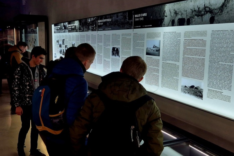 uczestnicy wycieczki przed tablicą informacyjną