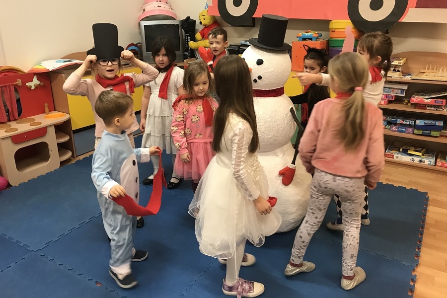 grupa dzieci tanczy z bałwankiem