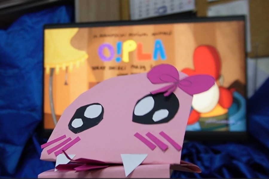 ekran z reklamą Festiwalu i papierowa postać